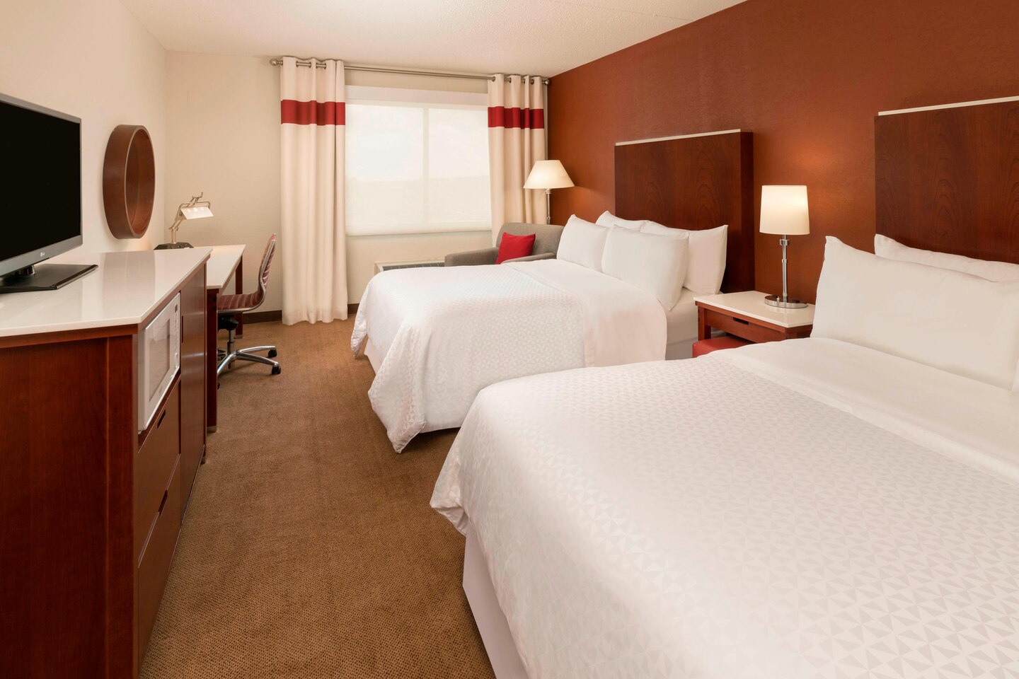 Four Points Sheraton Boston Logan Airport - Guest room with 2 double plush beds and comfortable armchair seating.
